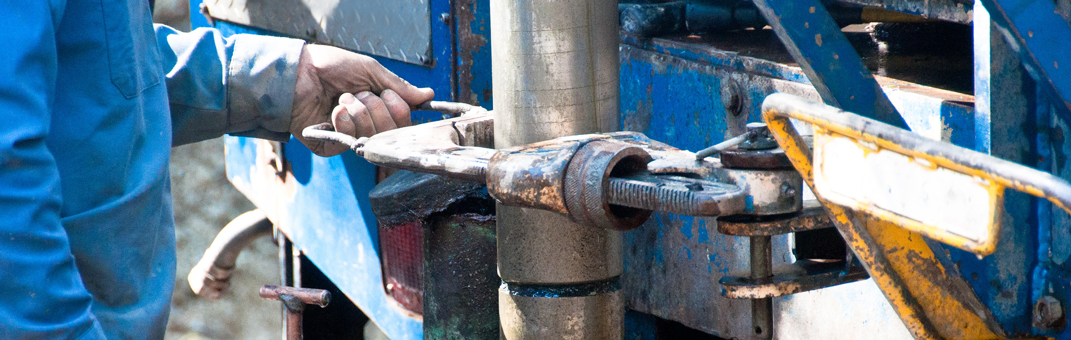 man using wrench to tighten drill auger